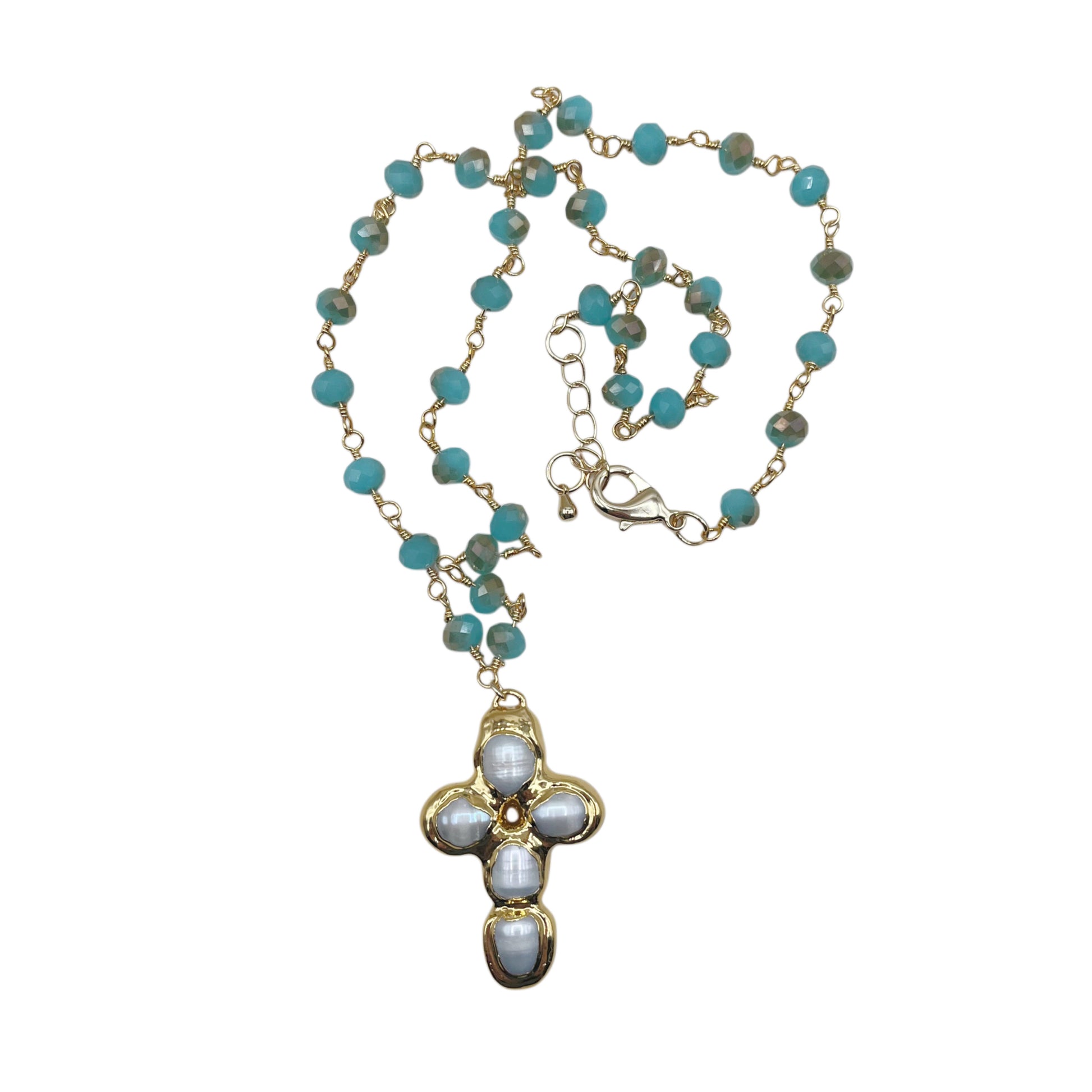 A gold-tone beaded necklace with turquoise blue beads and a cross-shaped pendant featuring white mother-of-pearl inlays, shown on a plain white background.