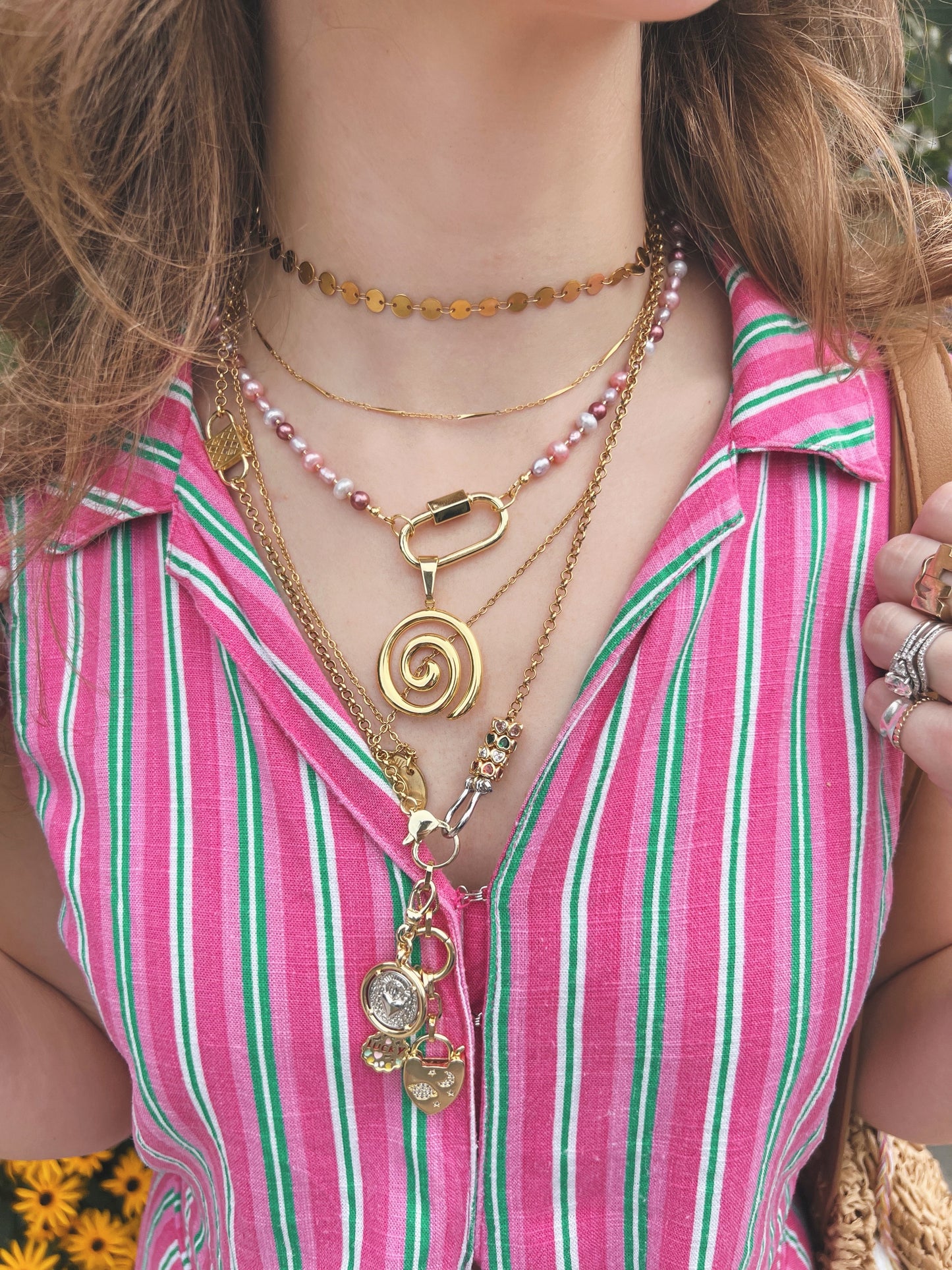 Close up of a woman wearing multiple gold necklaces
