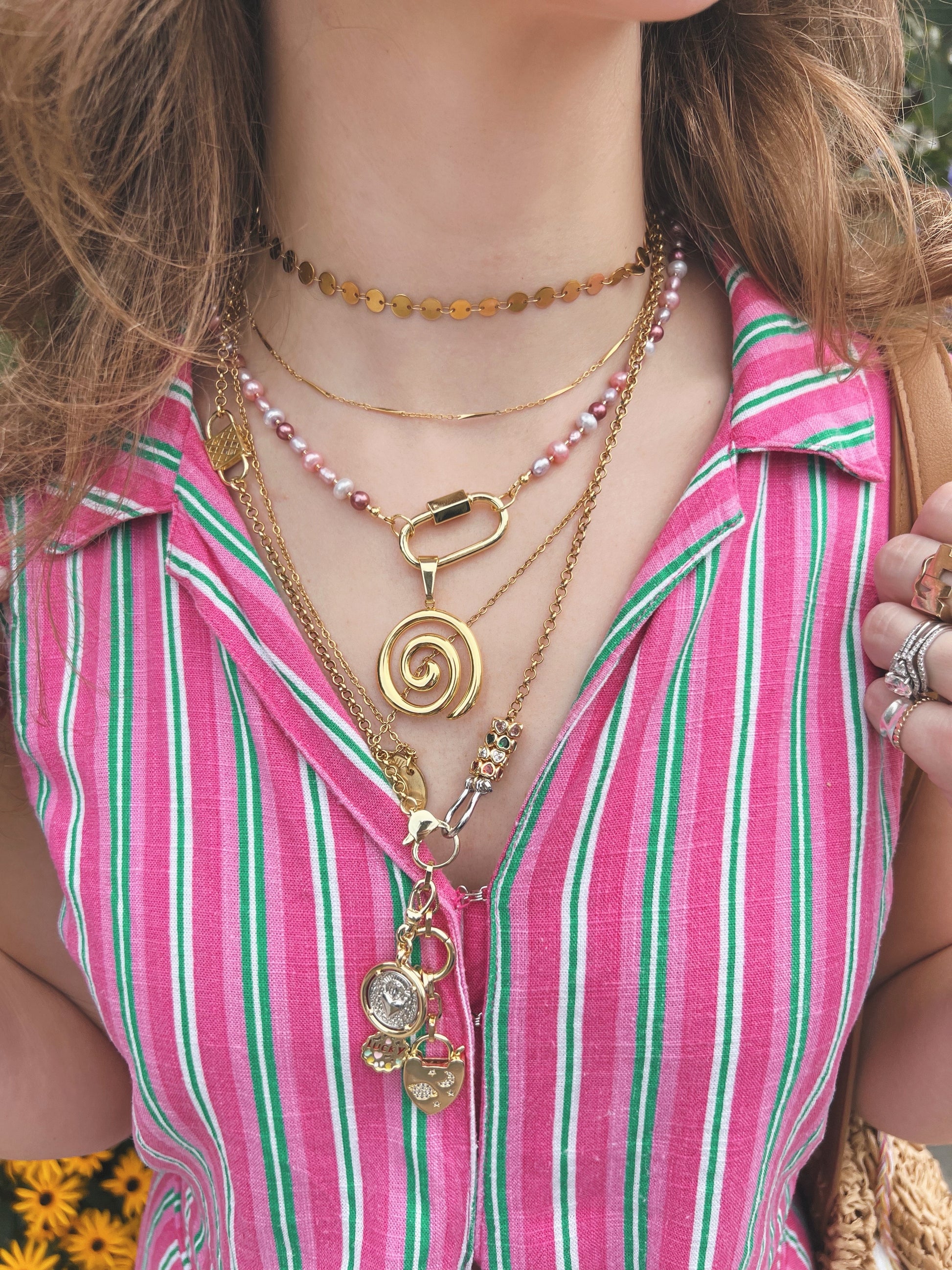 Close up of a woman wearing multiple gold necklaces