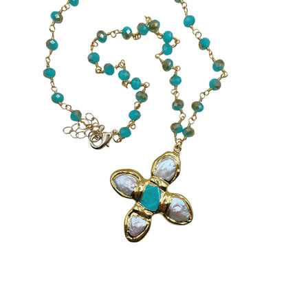 A gold-tone beaded necklace with turquoise blue beads and a central floral pendant featuring white mother-of-pearl petals and a turquoise center, shown on a plain white background.