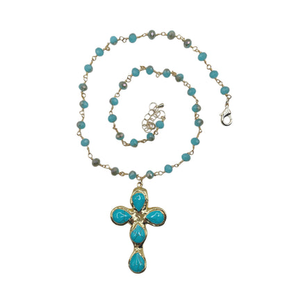 A gold chain necklace featuring turquoise blue beads and a matching cross pendant with turquoise stones, displayed on a clean white background.