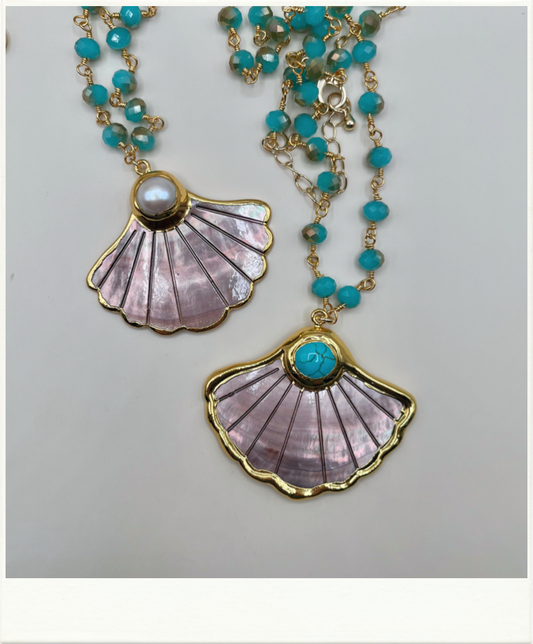 A gold-tone shell pendant necklace with turquoise beads, featuring two scalloped shell pendants with iridescent lavender-pink inlay and turquoise accents.